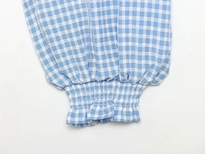 Detailed view of elastic cuffs on a blue and white checkered cotton shirt for women