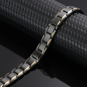 Herren Magnetarmband aus schwarz und gold beschichtetem Edelstahl auf schwarzer Textur