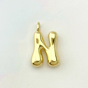 Detailed view of balloon style letter N pendant with a polished gold finish and round shape