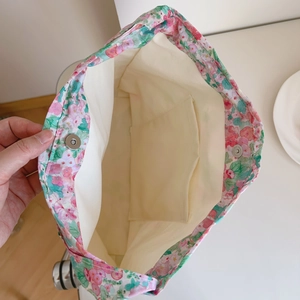 Detail view of floral canvas bag showing magnetic closure and interior pocket