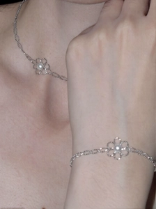 Detailaufnahme von silbernem Blumen-Halsketten- und Armband-Set mit Perlen an einem Model