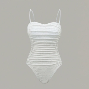 Detail of white one-piece swimsuit featuring floral eyelet fabric and ruched bodice detail