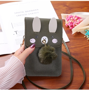 Detail of green crossbody phone bag featuring cute rabbit ears and a soft plush pompom