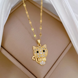 Macro detail of gold cat pendant with pavé set white crystals and black stone eyes