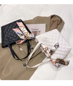 Detailed view of quilted tote bags in black and white with silk scarf handles