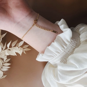Gros plan d'un bracelet plaqué or 18 carats montrant la gravure K18 et le fermoir mousqueton