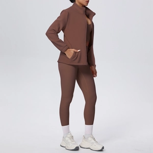 Dettaglio completo set yoga marrone con giacca zip a collo alto e leggings sportivi a vita alta