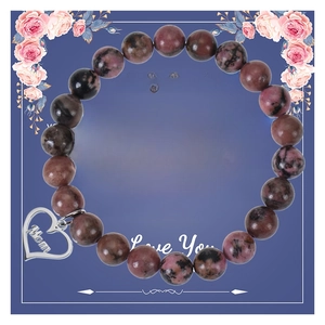 Bracelet en pierres roses avec pendentif cœur Mom sur fond de carte cadeau fleurie