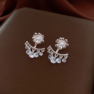 Detail of silver vintage flower earrings with central pearl and hanging zircon tassels