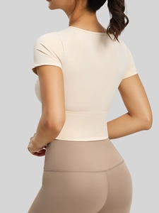 T-shirt da yoga crema aderente con spalline asimmetriche e leggings sportivi a vita alta