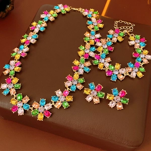 Macro shot of vintage gold flower jewelry set with colorful crystals on leather background