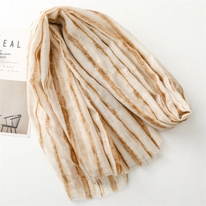 Detail of soft off-white cotton-linen scarf with brown stripes and fine silver glitter