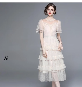 Detailaufnahme von gestuftem Spitzenkleid mit Stickerei und transparentem Ausschnitt