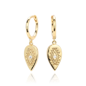Macro shot of gold teardrop earrings with geometric engravings and small clear crystals