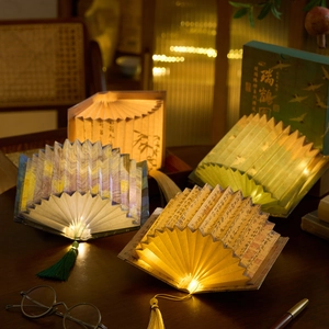 Foldable book lamp in fan shape featuring traditional art patterns and tassels