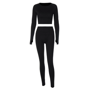 Detail of black ribbed knit seamless yoga set featuring long sleeve crop top and leggings