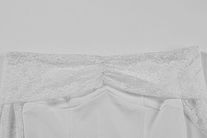 Close-up of white lace stitching and ruched detail on the off-shoulder neckline dress