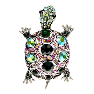 Macro shot of silver turtle brooch with emerald green crystals and colorful rhinestones