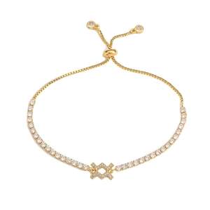 Detail of adjustable gold bracelet with zircon pavé and geometric cross charm