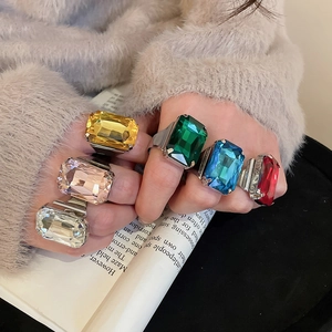 Detail shot of multi-color rectangular gemstone rings with wide silver bands on model