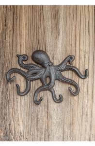 Detail eines antiken Oktopus-Wandhakens aus Gusseisen mit sechs Armen auf Holzgrund