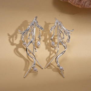 Silver branch earrings with pearls featuring organic twisted lines on beige texture