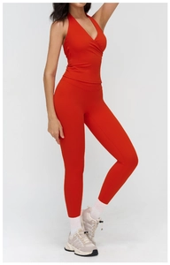 Detail view of red high-waist yoga leggings and halter neck top with cross-front design