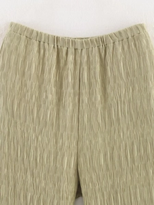 Détail du pantalon vert olive clair avec texture plissée verticale et taille élastique