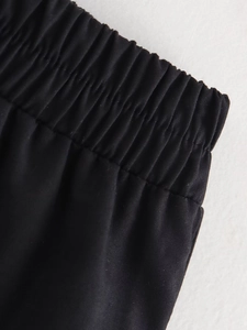 Gros plan de la taille élastique et des coutures précises sur ce pantalon noir de luxe