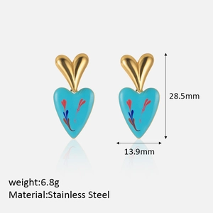Macro detail of blue heart earrings in stainless steel with floral patterns and measurements