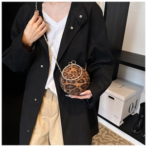 Detail of leopard print ball evening bag with gold chain and rhinestone ring handle