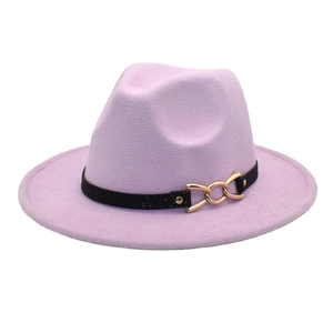 Dettaglio di un cappello fedora lilla con cintura nera e fibbia a catena dorata