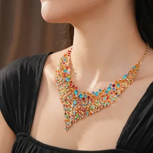 Vintage V-shaped gold necklace with colorful crystals on model neck close-up