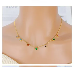 Detailed view of golden necklace with seven colorful heart-shaped crystal pendants on model