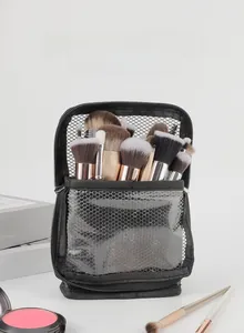Vertical black mesh makeup brush bag with large capacity standing on a white surface