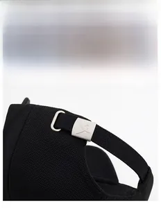 Detail view of the adjustable silver metal buckle on a black twill baseball cap strap