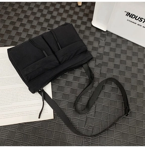Detailed top view of a black nylon messenger bag with multi-pocket utility design