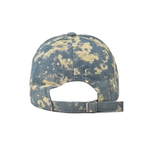 Detail van de denim baseballpet achterkant met gouden ster maan patches en metalen gesp