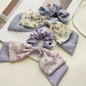 Detailed close-up of floral double-layered bow hair ties in satin light blue and lilac colors
