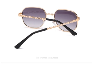 Detail of gold metal sunglasses frame with unique chain temple design and gradient lenses