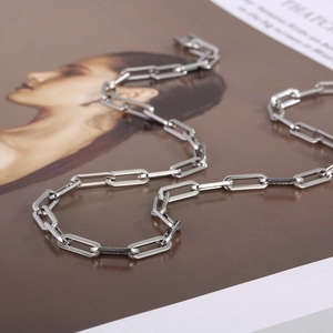Polished stainless steel paperclip link chain necklace displayed on a magazine