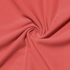 Close-up of coral pink knit fabric showing soft texture and premium draping of the T-shirt set