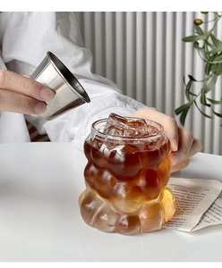 Detail of pouring liquid into a heat-resistant cloud shaped glass cup with ice
