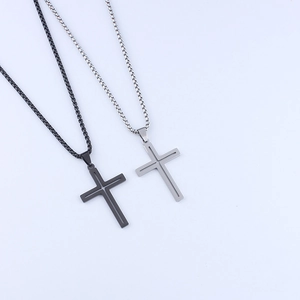 Detailed view of hollow cross pendants in black and silver polished stainless steel