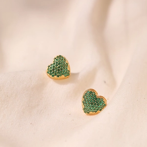 Detailed macro of heart-shaped gold studs with pavé emerald green cubic zirconia