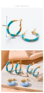 Detail showing 2.8cm C-shape threaded gold-plated hoop earrings with blue enamel finish
