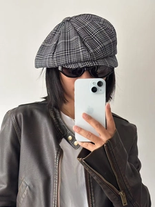 Detail of checkered newsboy cap in black and white pattern with vintage styling