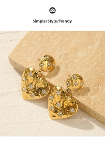 Macro view of 14k gold-plated heart drop earrings featuring hammered metal texture and zircons