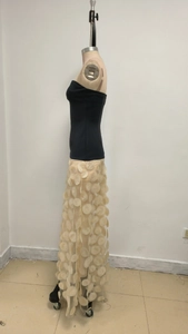 Detail of elegant black tube top dress with cream floral mesh skirt on a mannequin