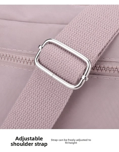 Detail view of pink nylon shoulder bag with adjustable strap and silver metal buckle